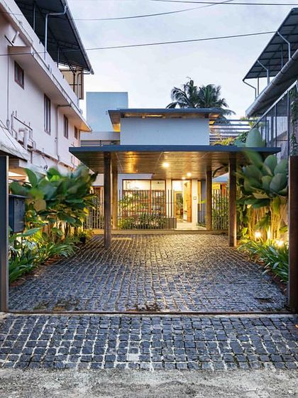 The entrance to 'HAVEN' by VSP Architects in Cochin, where a cobblestone driveway leads to a home designed to be an urban sanctuary, shielded from the dense city surroundings.