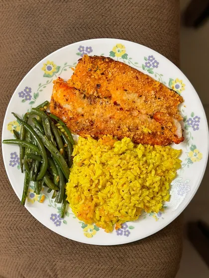 A delicious plate of baked salmon, turmeric rice, and green beans. Salmon is an excellent source of omega-3 fatty acids and protein.