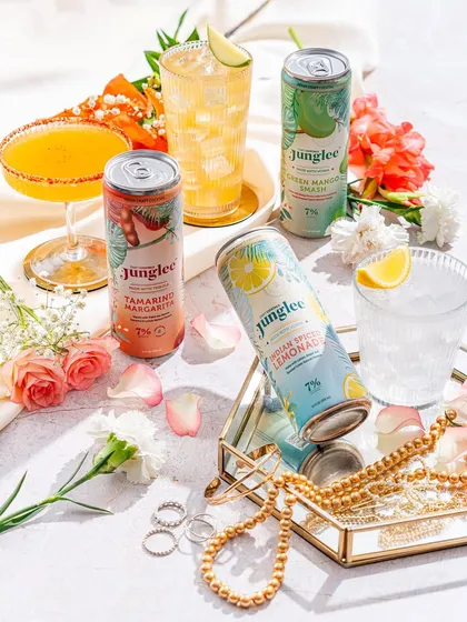 A soft and romantic setting for Junglee cocktails, styled with fresh flowers and delicate jewelry. This shows the brand's versatility, fitting even into a more feminine, celebratory context.