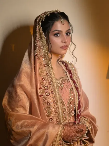A portrait of the bride, her regal look completed with a traditional passa and maang tikka.