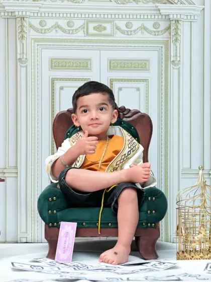 A confident little boy gives a thumbs-up from his miniature armchair. This vintage-themed set features an old telephone, a gramophone, and a classic wall design for a sophisticated portrait.