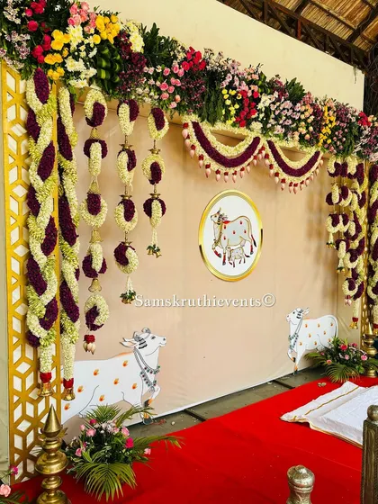 A beautiful backdrop with a custom illustration of a cow and calf, a sacred symbol in our culture. The design is framed by intricate floral garlands, blending artistic and traditional elements perfectly.