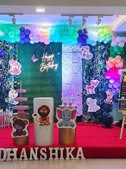 Another angle of the enchanting woodland animal first birthday, highlighting the mix of a shimmer wall and a greenery backdrop for a touch of sparkle.