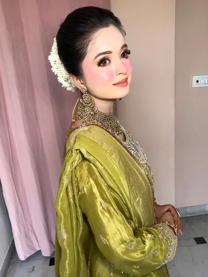 The side profile shows off her elegant bun and the heavy, detailed earrings.