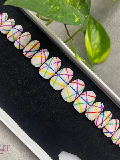 How about just some colorful lines? This fun press-on set features a milky white base with a crisscross pattern of rainbow-colored lines.