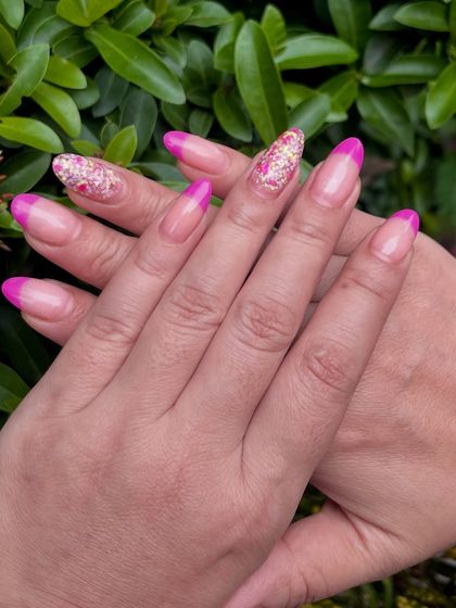 Another angle of the unique French Dip manicure. The crisp pink line and the dense glitter coverage on the accent nail are hallmarks of a quality dip powder application.