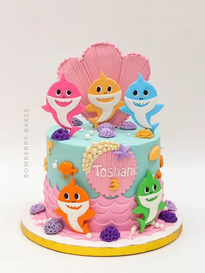 A vibrant Baby Shark cake for a 3rd birthday, with the whole shark family swimming around an underwater scene.