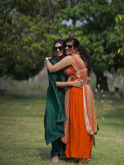 A warm hug between the bride and a loved one at her outdoor mehendi ceremony.