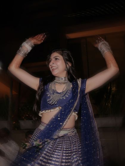 The bride in her element, dancing with joy, her silver tribal jewellery adding the perfect touch to her traditional look.