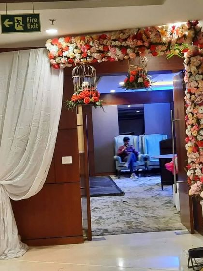 An entrance to a party hall decorated with a lush floral arch. I also hung birdcages filled with flowers for a whimsical touch.