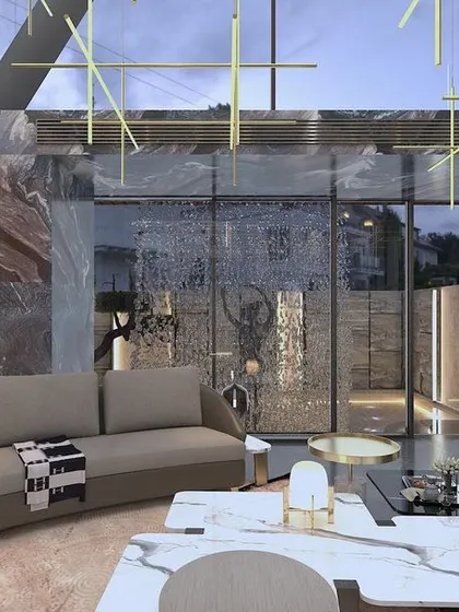 This double-height living room embodies opulence. We used bookmatched marble slabs to create a dramatic feature wall, while our custom-designed brass lighting grid descends from the ceiling, illuminating the space and our in-house manufactured curved sofa.
