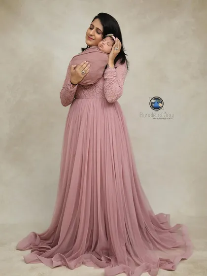 A mother's first embrace is a memory to cherish forever. I provide a selection of beautiful gowns, like this flowing pink one, for moms to wear during their newborn family portraits, creating timeless and elegant images.