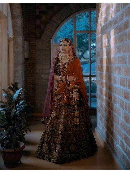 A full-length portrait of Nisha in a grand corridor, her pose exuding confidence and elegance.