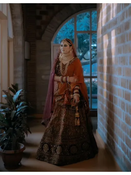 A full-length portrait of Nisha in a grand corridor, her pose exuding confidence and elegance.