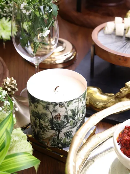 Our jungle-print scented candle, styled on a festive tablescape. Its subtle fragrance and beautiful design add to the overall ambiance of the gathering.