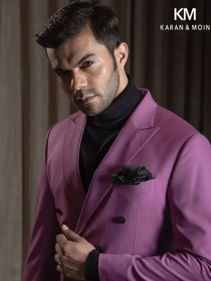 A bold statement in this magenta double-breasted blazer. Paired with a black turtleneck, it’s a confident look for a man who isn’t afraid of color.