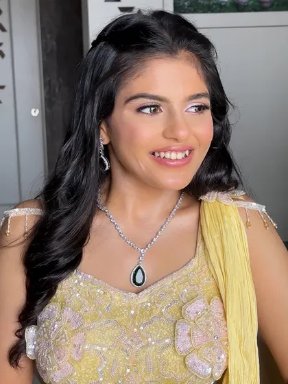 Making Zeel glow in her golden hour of love. For this bride's engagement, we created a soft and shimmery look with a pop of pink on the eyes to complement her yellow outfit. 🤍