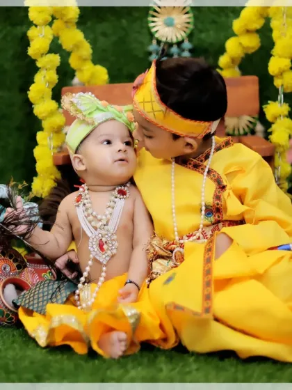 I also include siblings in themed shoots. Here, an older brother, also dressed in yellow, shares a sweet moment with his baby sibling during a Krishna-themed session.