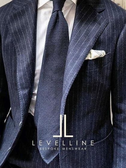 The complete look: a classic navy pinstripe suit paired with a crisp shirt and tie. This is the uniform of success, tailored by us to fit you perfectly.