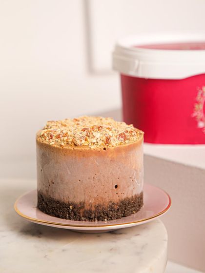 A mini ice cream cake on a pink plate, showing the rich layers within. A perfect single-serving version of our larger cakes.