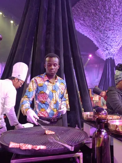 A chef from our international team at a live grill, showcasing the global culinary talent we bring to our events.