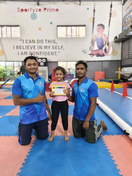Two coaches celebrate with a young gymnast who has just earned her certificate. It's a team effort, and we are proud of them all.
