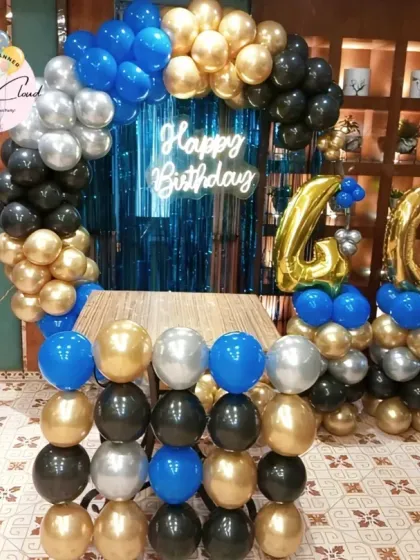 A bold blue, black, and gold balloon setup for a 40th birthday party in a restaurant.