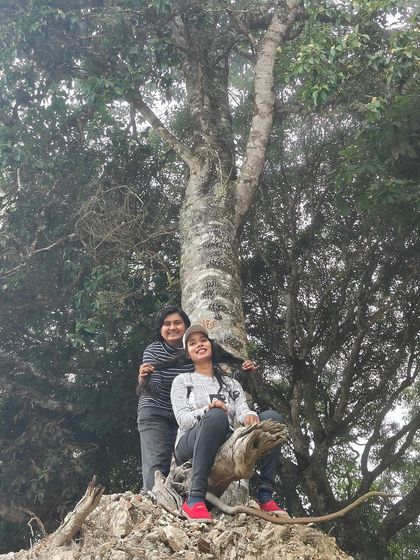 Two friends posing by a tree in Kodaikanal.