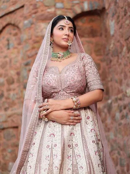 Another angle of the bride in her royal pastel lehenga. The stone wall in the background adds to the historic, regal vibe.