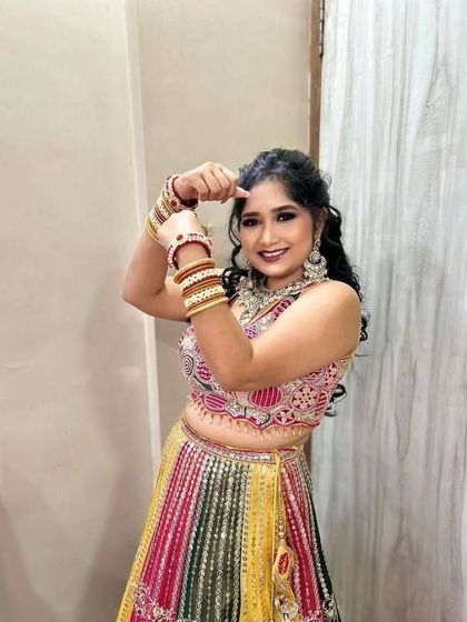 Fun and playful poses for the Sangeet night. This bride's multi-colored lehenga is paired with a dramatic eye and a joyful smile.
