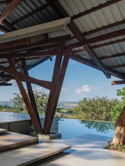 The Lateral Verandah House in Lonavala is designed to merge with the hillside. The unique timber frame structure and infinity pool create a space that feels both sheltered and completely open to the expansive views.