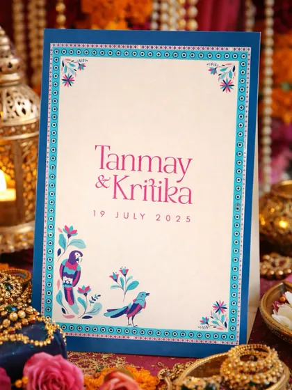 For Tanmay and Kritika, we created this vibrant invitation using a unique color palette of blues and pinks. The design features custom bird illustrations and a protective evil eye border, reflecting their personalities and journey together.