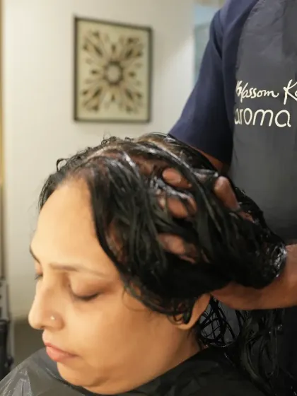 A close-up of our hair spa treatment in progress. The therapist thoroughly works the nourishing product into the hair and scalp, ensuring every strand receives the benefits.