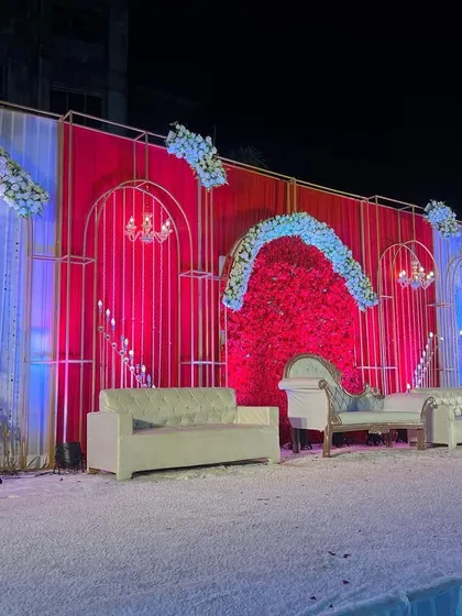This angle captures the dynamic lighting on the red and white stage. The use of both red and blue uplighting adds depth and changes the mood of the space.