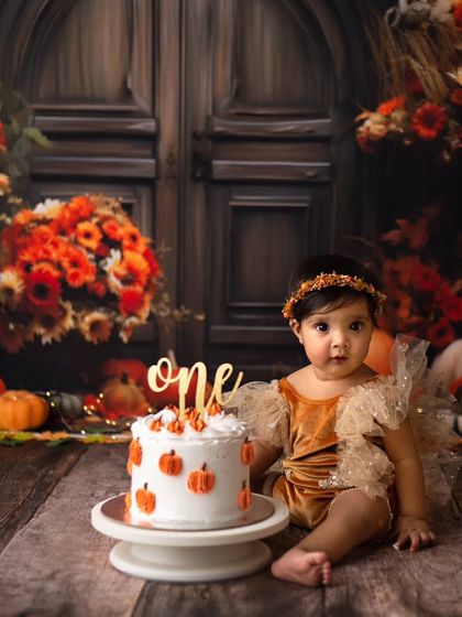 A quiet moment with her first birthday cake. This little princess looks so sweet and thoughtful in her gorgeous fall-themed setup.