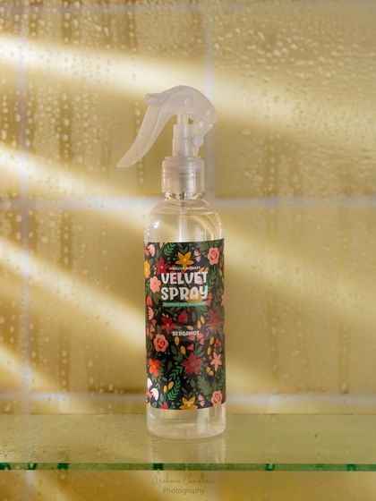 A creative shot of a body spray seen through a glass panel with fake condensation. This technique adds a refreshing and steamy bathroom feel to the image.