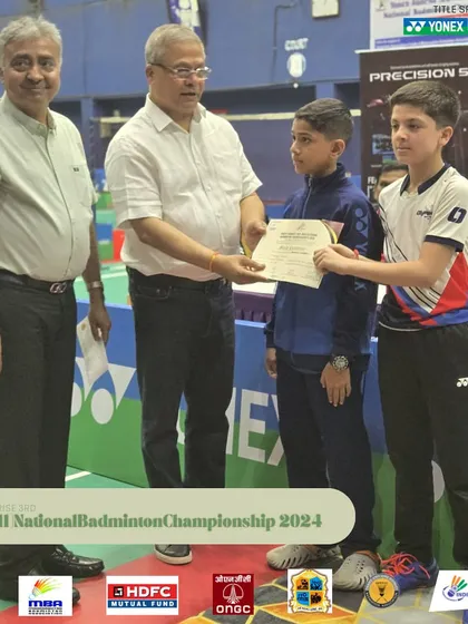 A young player receiving his certificate at the Mini National Badminton Championship.
