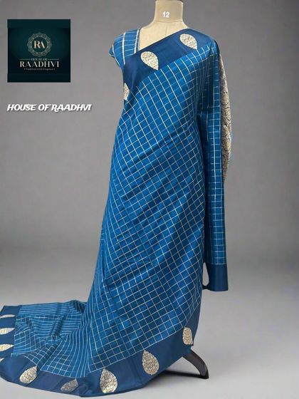 A restocked checks pattern pure Banaras lightweight silk saree in a beautiful peacock blue.