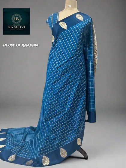 A restocked checks pattern pure Banaras lightweight silk saree in a beautiful peacock blue.