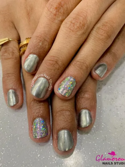 A modern and chic combination of metallic silver chrome nails and accent nails covered in multi-colored holographic glitter. It's a perfect mix of sleek and sparkly.