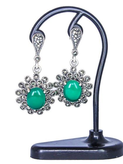 A pair of traditional floral earrings featuring a large green center stone surrounded by sparkling marcasite. This is a classic design from our ethnic collection.