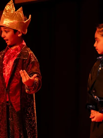 A tense interaction between the Emperor and another character. This highlights the children's ability to create and hold dramatic tension through their performance.