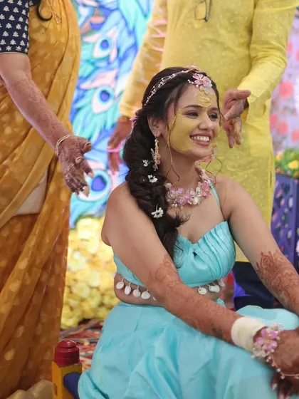 The bride enjoying her Haldi ceremony with a smile. Her intricate floral braid not only looks beautiful but is also designed to stay perfectly in place throughout the festivities.