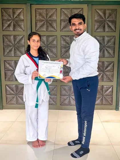 Presenting a certificate to a student, recognizing her hard work and progress.