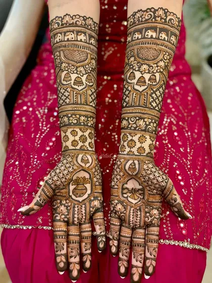 Full bridal mehendi featuring auspicious 'kalash' (pot) symbols, elephants, and hanging bells, perfect for a traditional wedding ceremony.