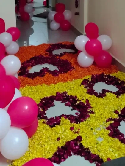 A flower petal pathway is a simple way to make a big impact. For this entrance, I created a dense carpet of yellow and orange marigold petals, with heart shapes outlined in red rose petals and flanked by balloon clusters.