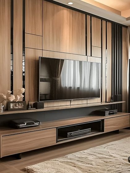 We designed this full-wall TV unit with a mix of wood and black accents for a sleek, modern look. The paneling adds texture and depth, while the ample storage keeps the living area organized.