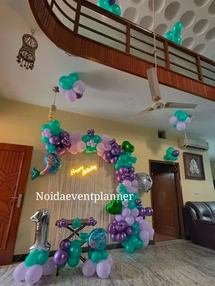 We can transform any space, even at home, with a fun theme like this mermaid birthday setup using balloon garlands, foil character balloons, and a neon sign.