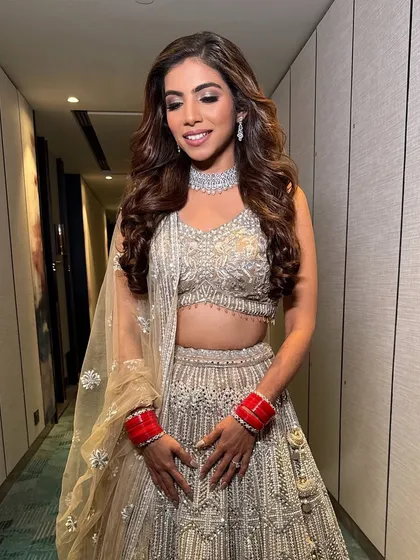 Where chic meets class, and glam takes center stage. This bride is ready for her reception in a stunning silver lehenga, with smoky eyes and beautiful wavy hair.