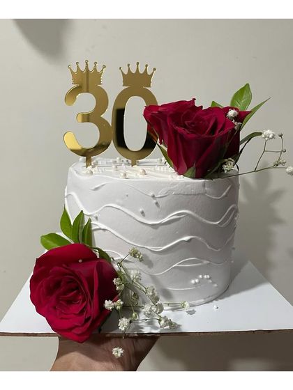A half-kg Blueberry cake for a 30th birthday. The simple white design is elevated with fresh red roses and a golden "30" topper.